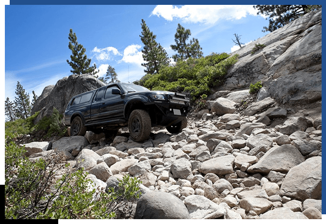 A black truck is parked on the rocks